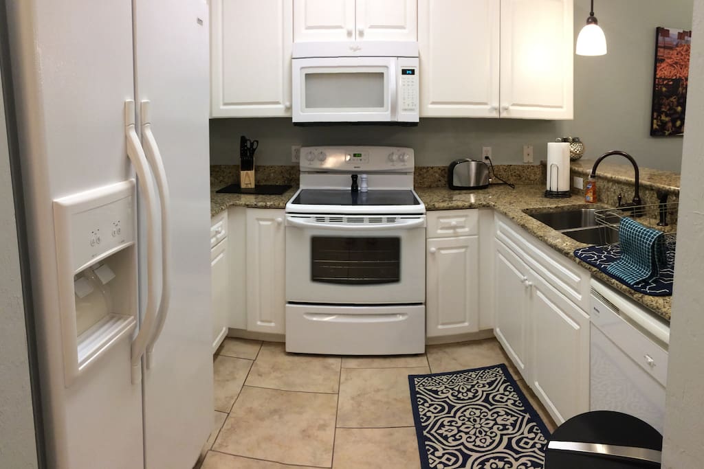 Fully equipped kitchen with granite counters, plenty of storage space, pots, pans, dishwasher, and more.
