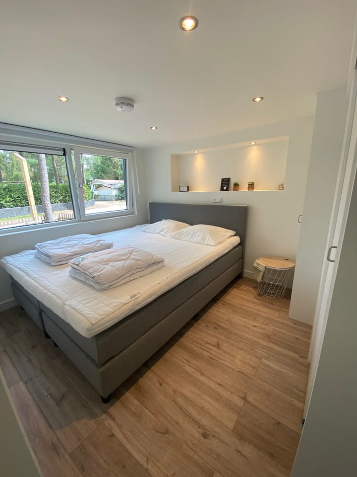 ห้องนอนมีฐานรองที่นอนขนาดกว้างขวาง 180x200 ซม. ผนังตู้เสื้อผ้าและซุ้มประตูพร้อมไฟส่องสว่าง 