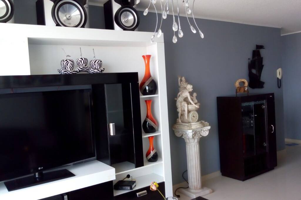 Sala con sillón completo y tv 47" + equipo de sonido, zona bien iluminada. Vista al mar.