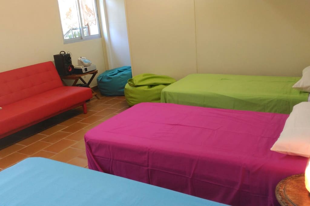 tres camas para compartir con otros huespedes o de un mismo grupo , sofa , estantes