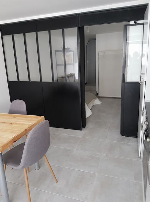 Cuisine à droite, salle à manger à gauche, chambre séparé par une verrière et porte coulissante