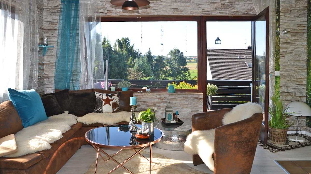 The cozy living room with additional sofa bed (left, extendable to 1.20 x 2.00 m), Magenta TV etc. offers a beautiful view. The balcony door leads directly onto the veranda, where you can sit outdoors but covered.