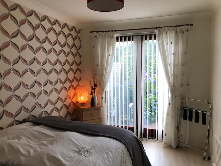 Downstairs bedroom with access to back garden with double bed fitted with smart tv 