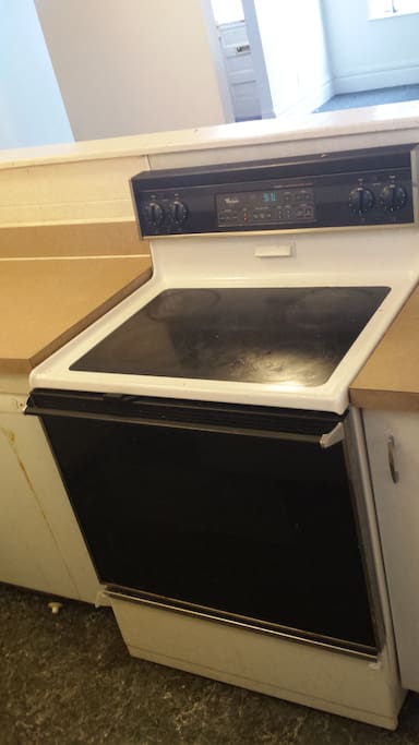 Kitchen with electric stove, refrigerator