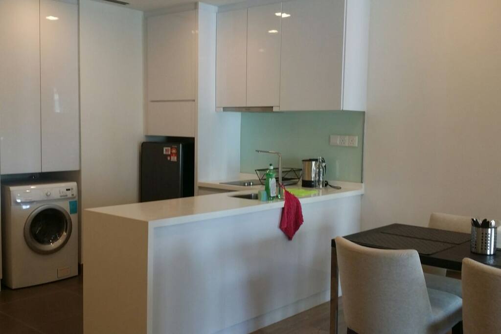 Kitchen with kettle, refrigerator and washing machine.