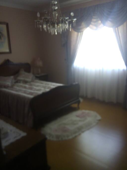 Quarto com cama de casal, roupeiro e comoda.