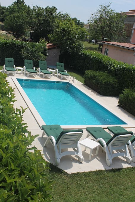 The swimming pool behind the apartman , common with another two apartams.