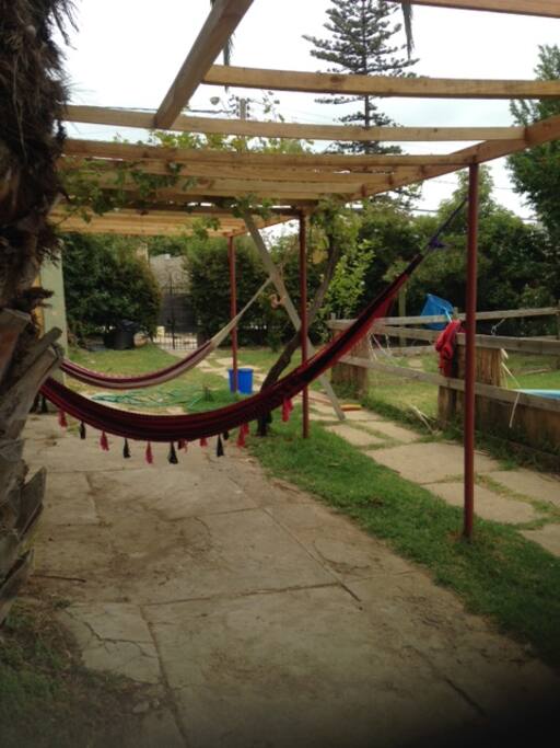 Jardín con pequeña piscina y parrón