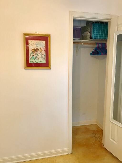 Closet with hangers and extra blankets.