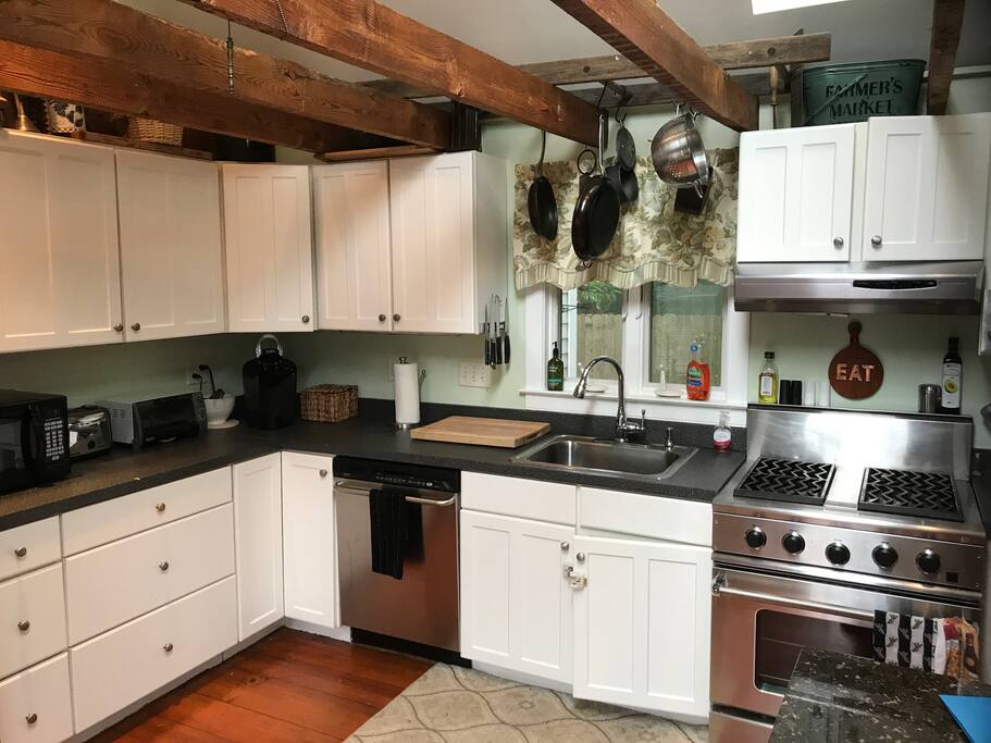 Well equipped kitchen with commercial DCS range and exposed beams.