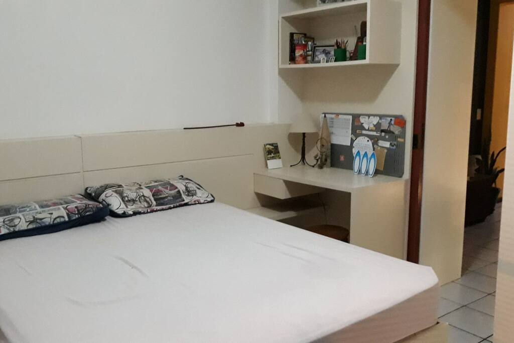 Cama casal e escritório no quarto.