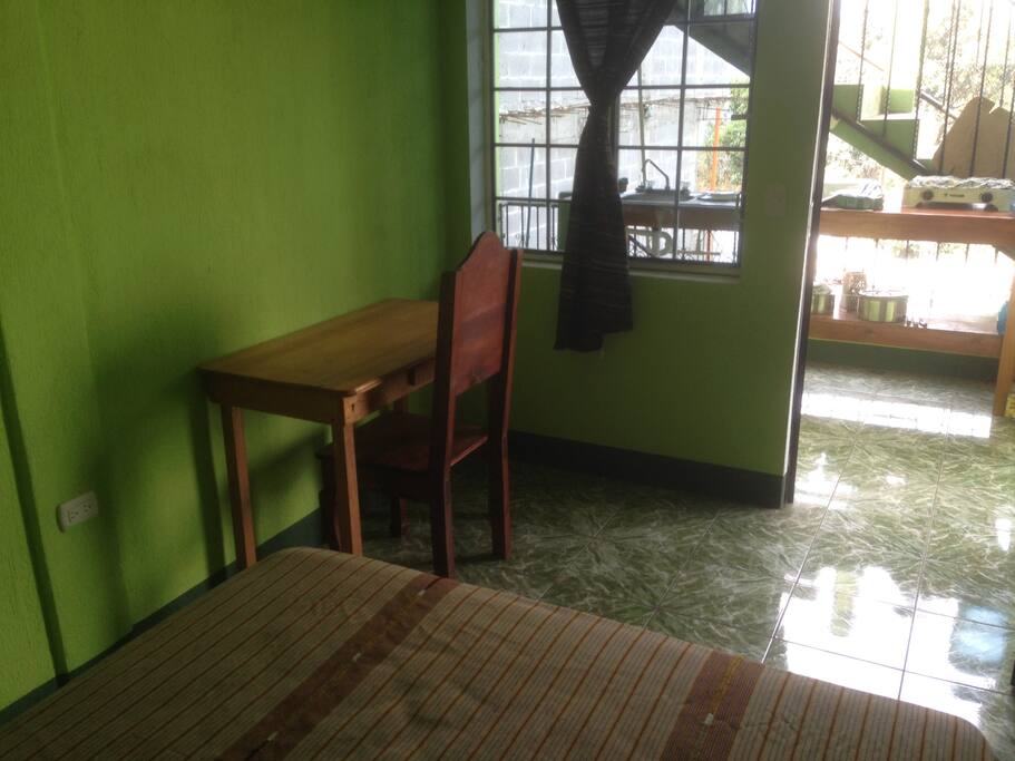 Directly in front of the shared kitchen with stove, fridge and kitchen sink.