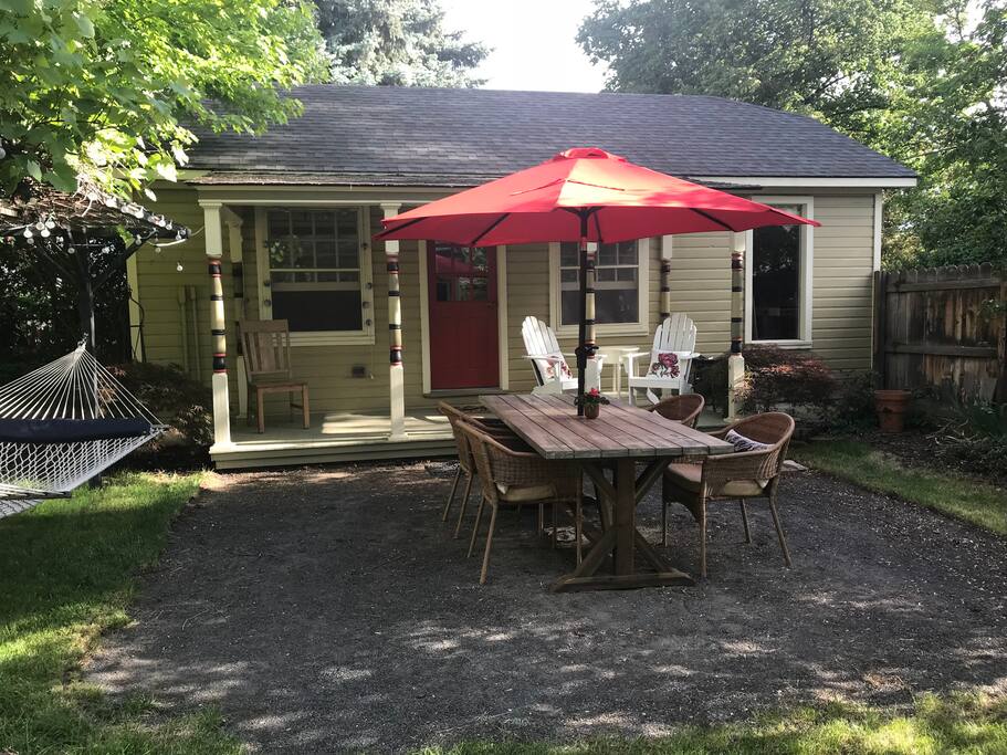 The Cottage - outdoor patio area with table, porch chairs and a hammock!