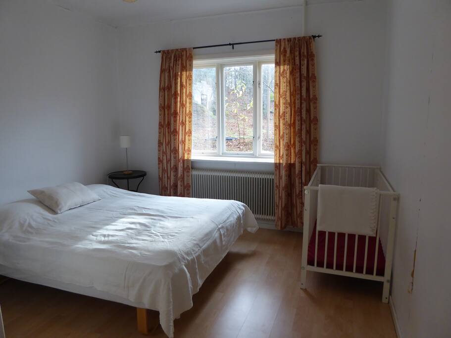 Sovrummet på bottenvåningen med dubbelsäng och en spjälsäng.