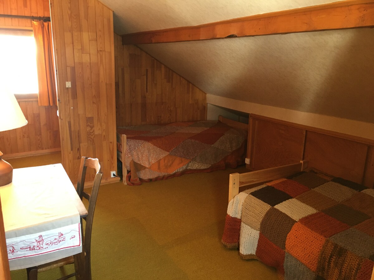 Première chambre sous les toits; deux lits avec un coin lavabo en haut de l'escalier à l'entrée de la chambre.