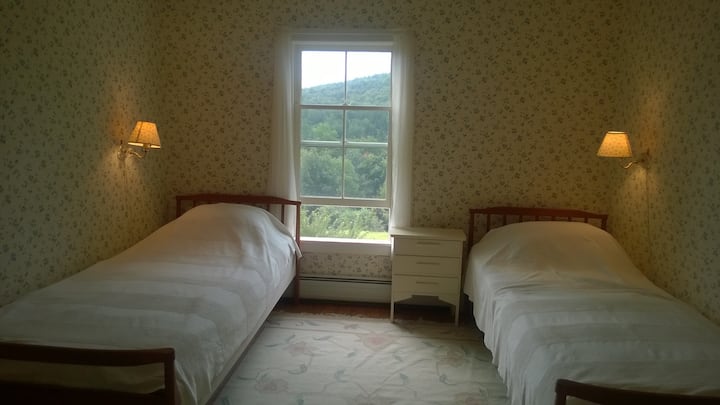 La habitación Valley tiene dos camas individuales extra largas y una vista de las colinas. Dormitorio #6.