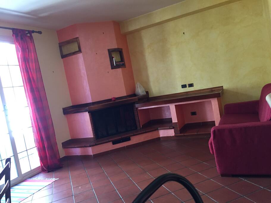 Soggiorno con camino e divano letto matrimoniale