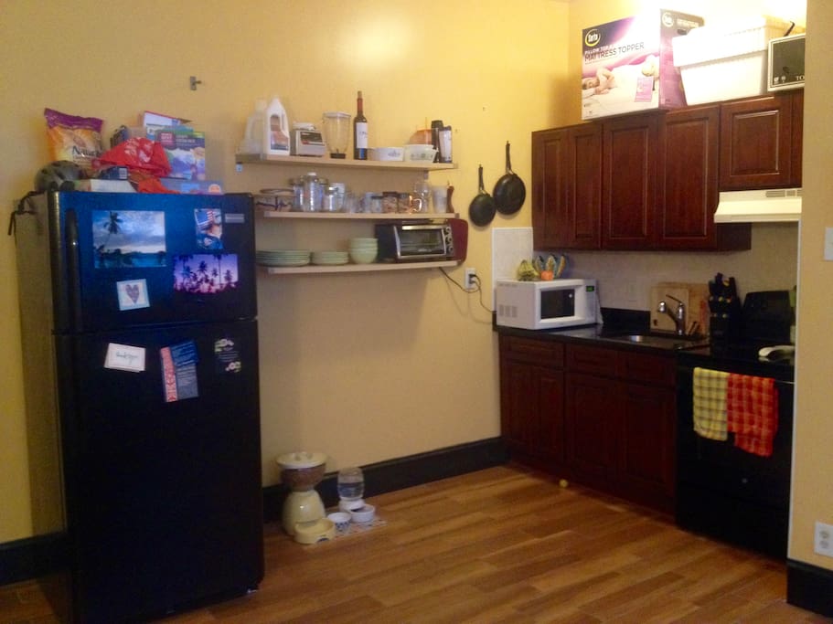 Kitchen with full fridge, microwave, toaster, oven etc.