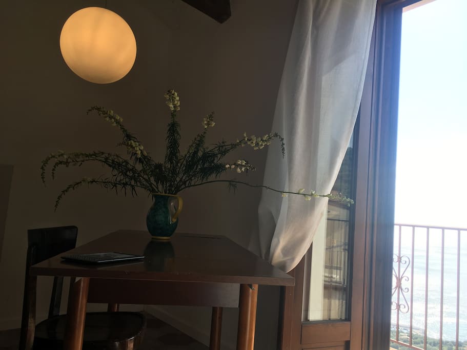 Private balcony and desk space with a view to the sea.