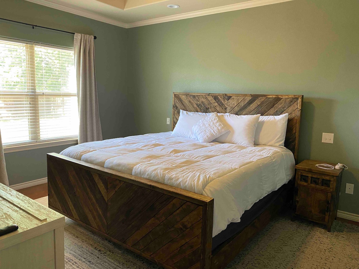 Pana chumba cha kulala cha msingi na kitanda cha mfalme. Mapazia meusi yameongezwa kwa ajili ya asubuhi hizo wakati unataka kulala. Pia utapata chaja kila upande wa kitanda ambazo zinachukua aina kadhaa za vifaa. 