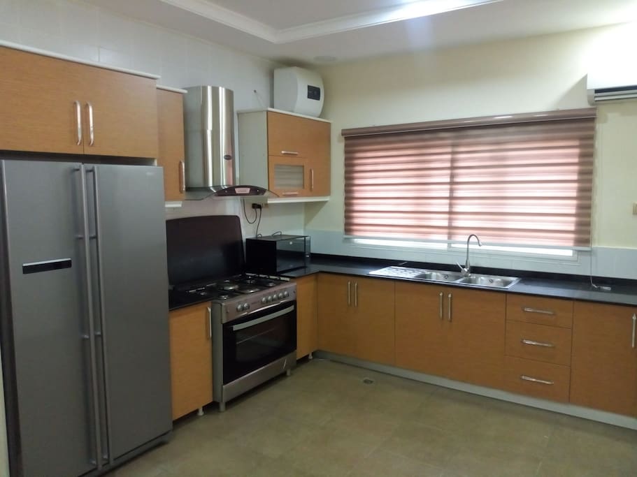 Fitted kitchen with double-door fridge, gascooker, oven, microwave oven, blender, coffee maker etc