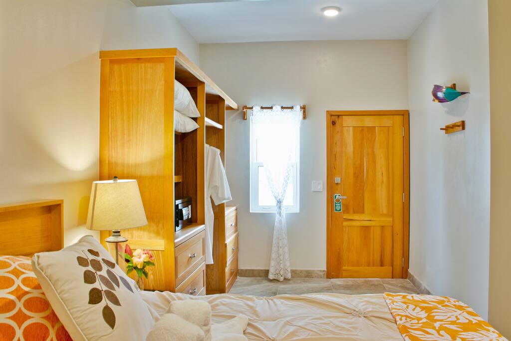 Bedroom King-sized bed, custom Mahogany closet/dresser, dressing area, AC and ceiling fan.