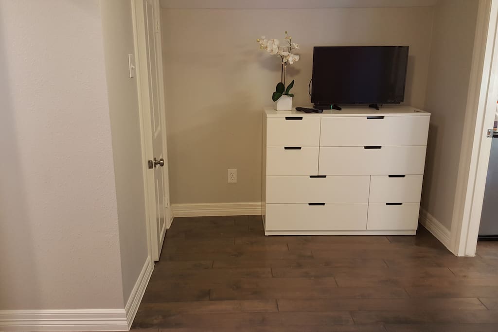 With a dresser and TV