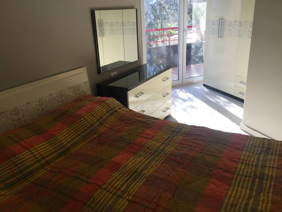 Sleeping room with a large double bed and closets.
