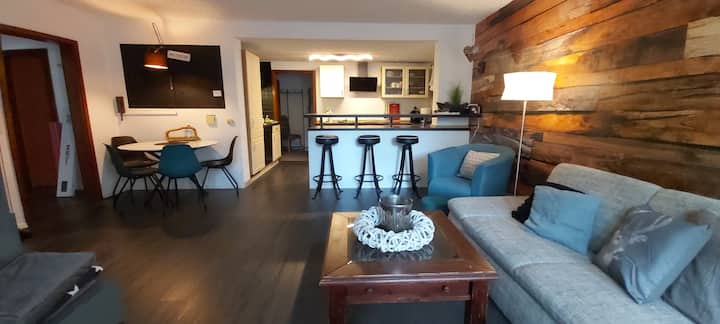 Living area with open kitchen and left of dining table 