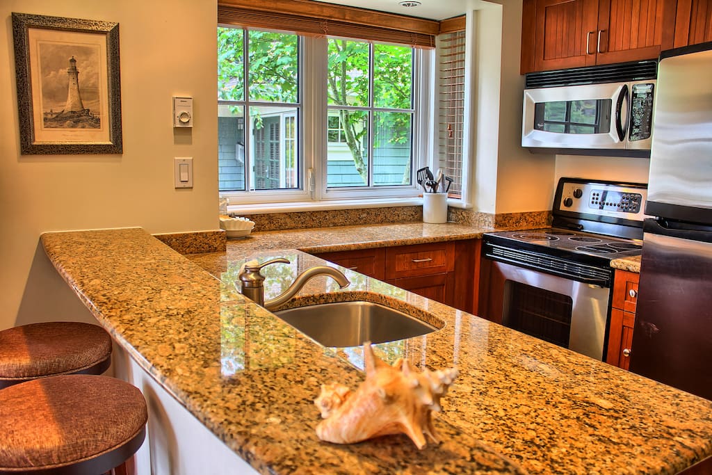 The kitchen features granite countertops and stainless steel appliances