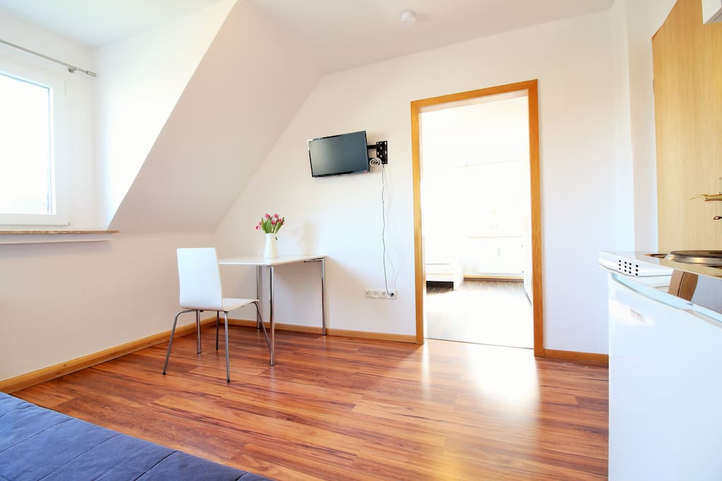 A kitchen table and a TV complement the living room.