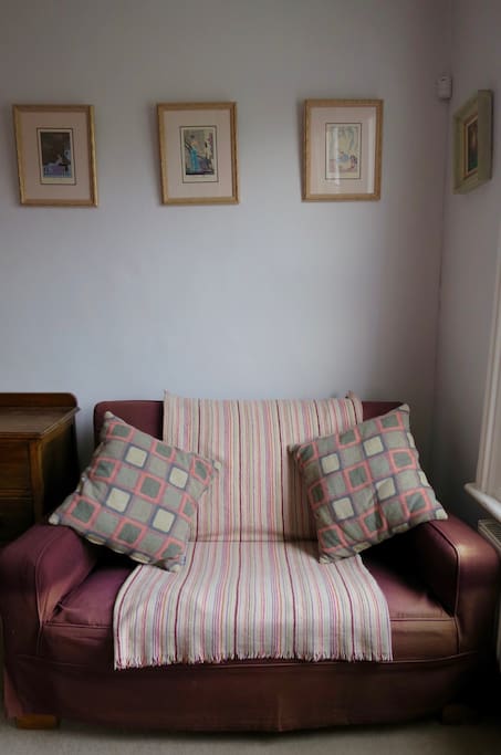 Sofa next to a window overlooking our neighbourhood in your room.