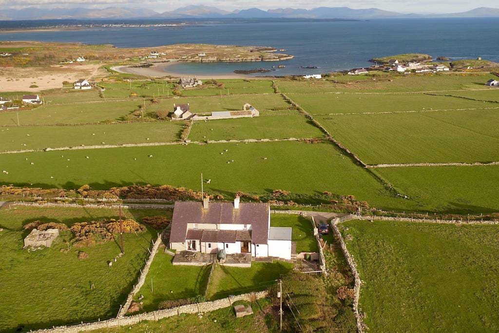 The view from the front of the house with Rhoscolyn Bay in the foreground and Snowdonia in the distance.