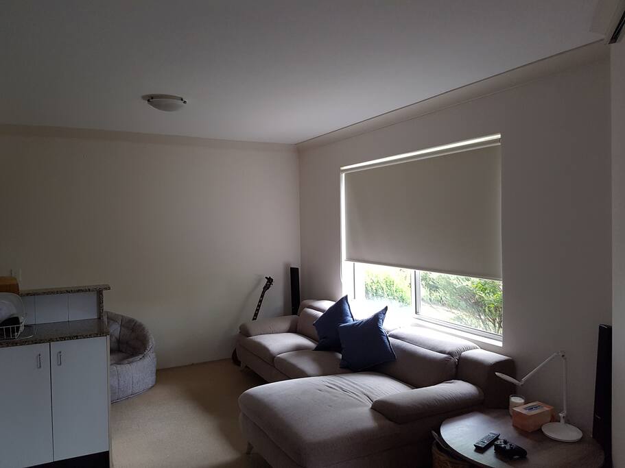 spacious lounge room with large flat screen TV and lounge for relaxing.