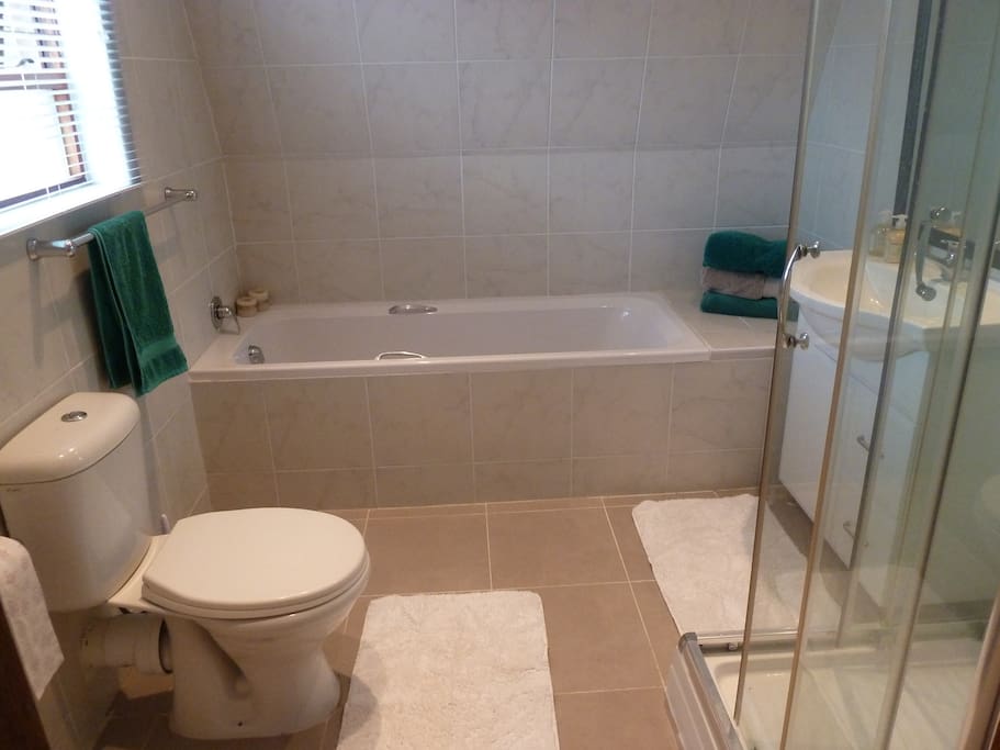 Large bathroom with soft bath towels, shower gel, shampoo and conditioner.