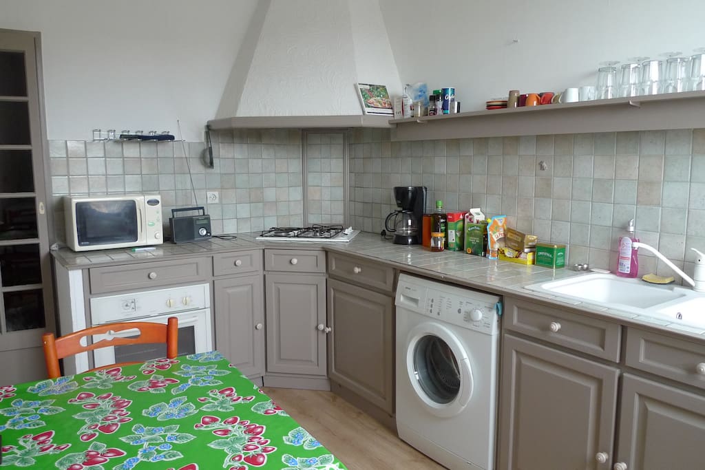 cuisine aménagée avec base de produits pour cuisiner, lave linge et lave vaisselle