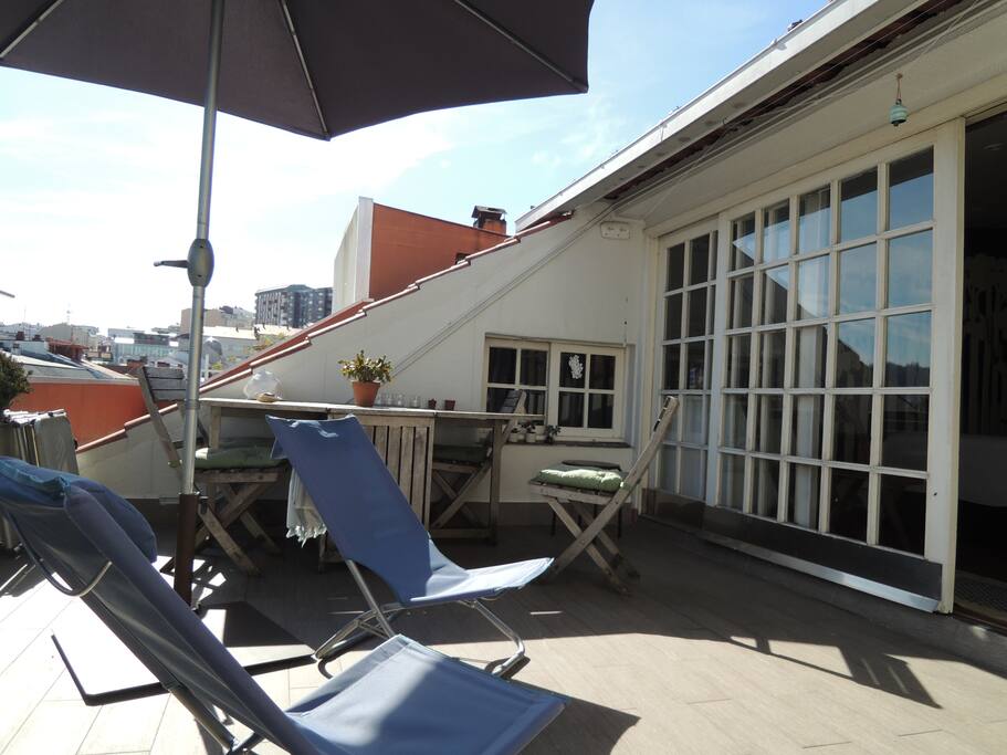 Terraza con sombrilla y tumbonas