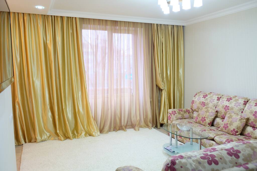 Large and bright living room, with a soft sofa right in front of a big HD TV!