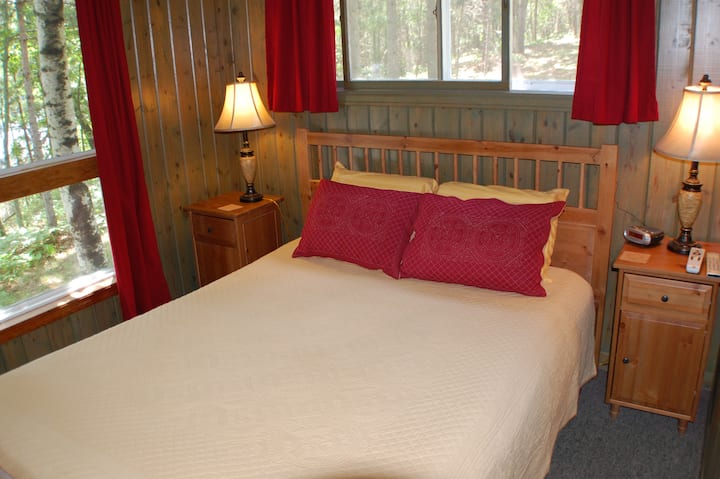 Dormitorio en el piso principal con cama tamaño Queen y vista al lago.