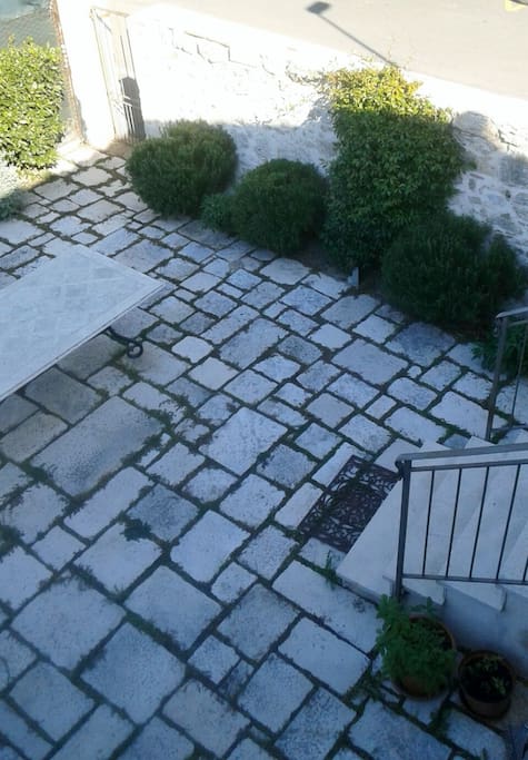 Il giardino con tavolo sedie e ombrello al piano terra.