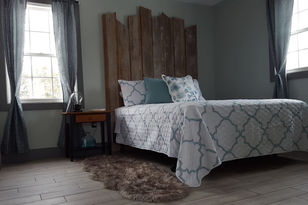 Bedroom - modern meets rustic with this comfortable queen bed and original one-of-a-kind hand-made barn-board headboard. Smart TV in bedroom where you can access Netflix. Ensuite bathroom separated by sliding barn-track door. Walk-in closet for plenty of storage space.