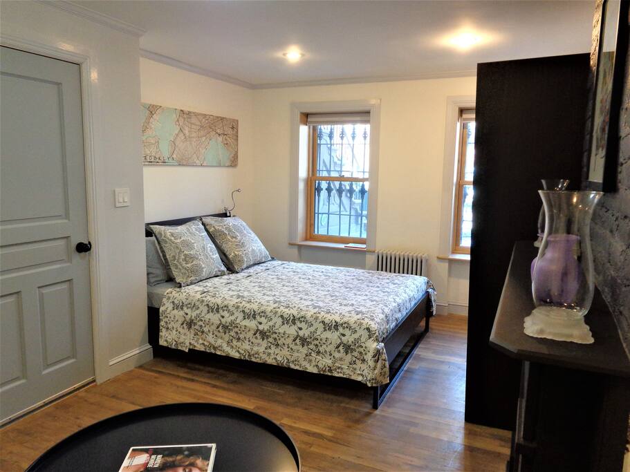 Bright, spacious first bedroom has large windows that bathe the space in daylight, and a queen-size bed that comfortably sleeps 2 guests.