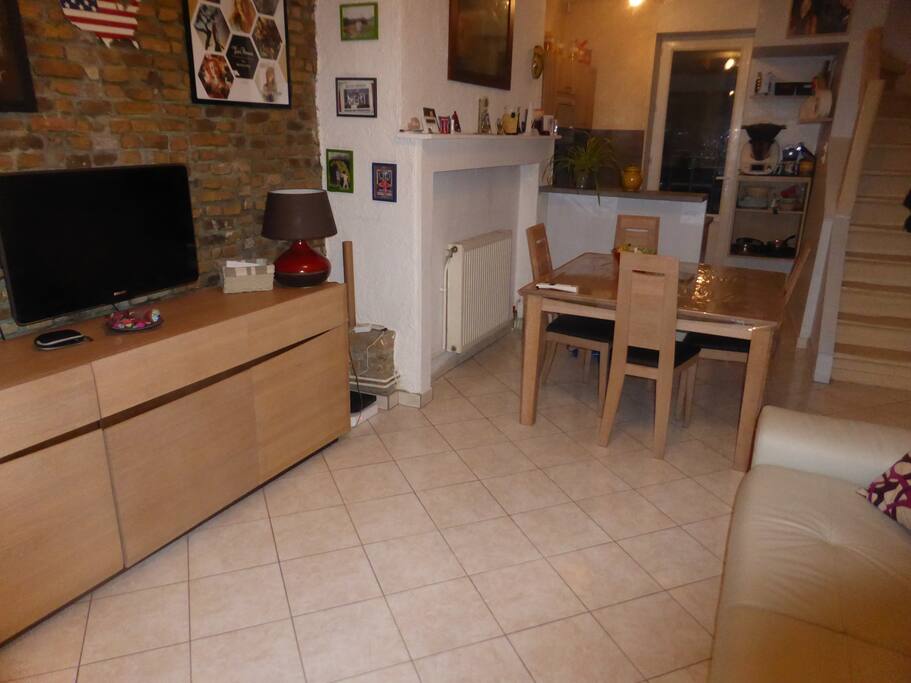Pièce à l'entrée, autre angle avec télé murale, bahut, table 4 places pouvant être élargie.