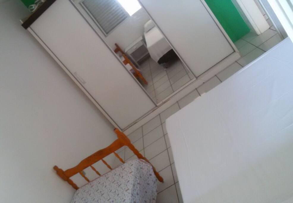 Quarto de casal com 1 cama extra de solteiro. Olhando da janela.