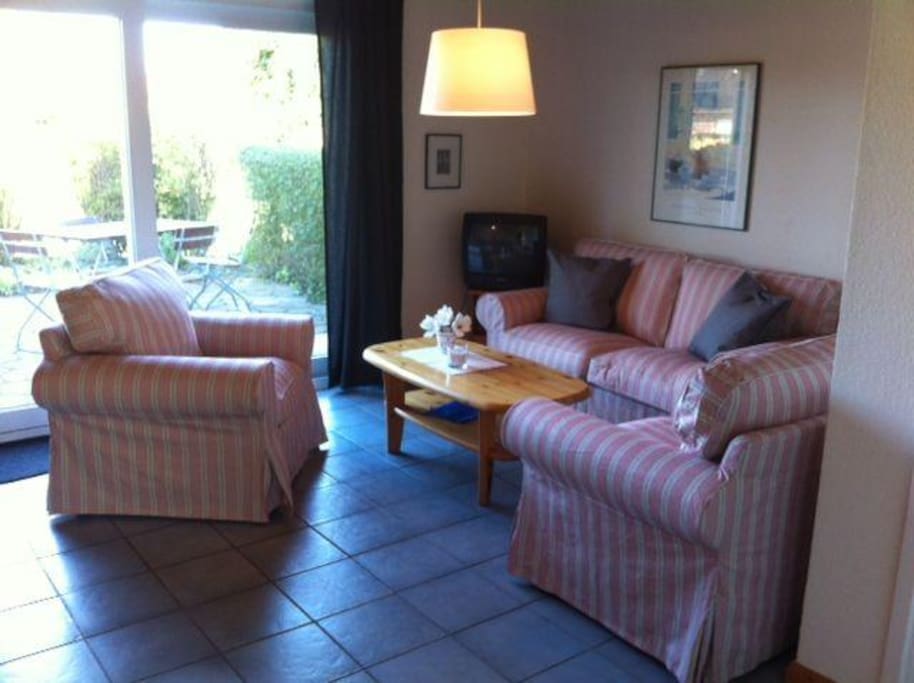 Neu gestaltetes, freundliches Wohnzimmer mit Ausgang zur eigenen Terrasse und zum Spielplatz.