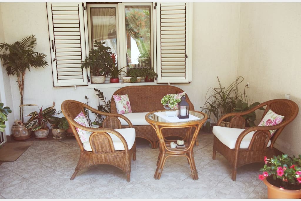 1st Floor: Large terrace with bamboo sofa set and Italian tiles surrounded by Mediterranean plants.