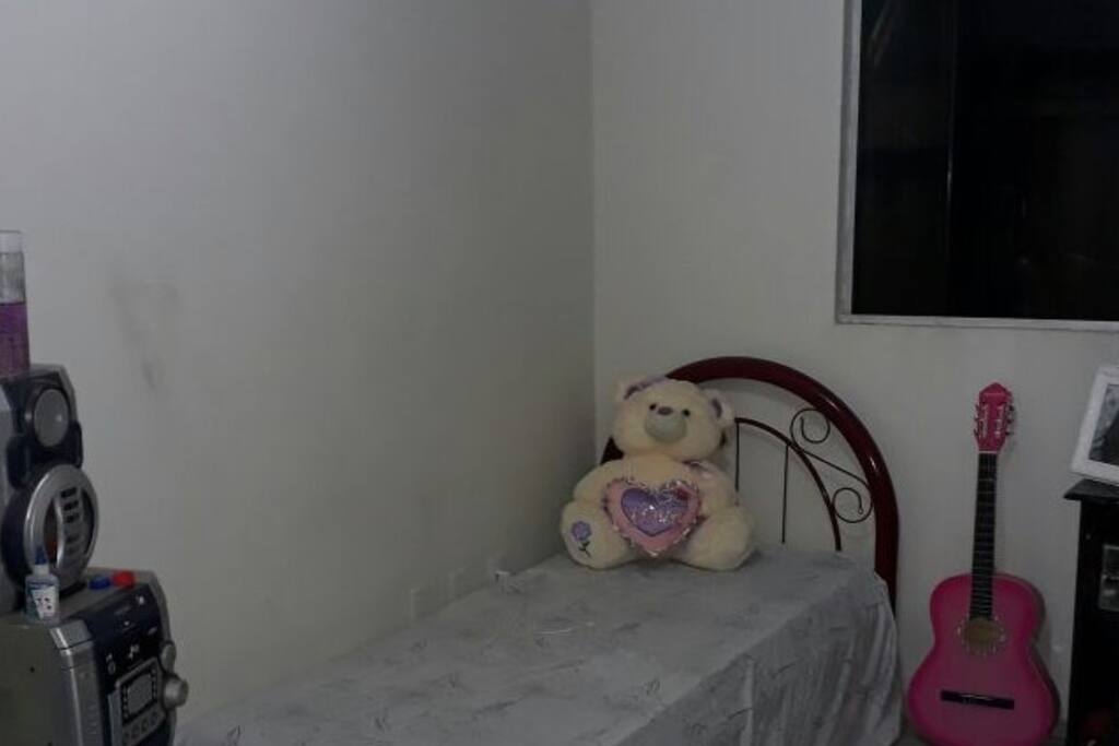 Quarto com cama de solteiro.