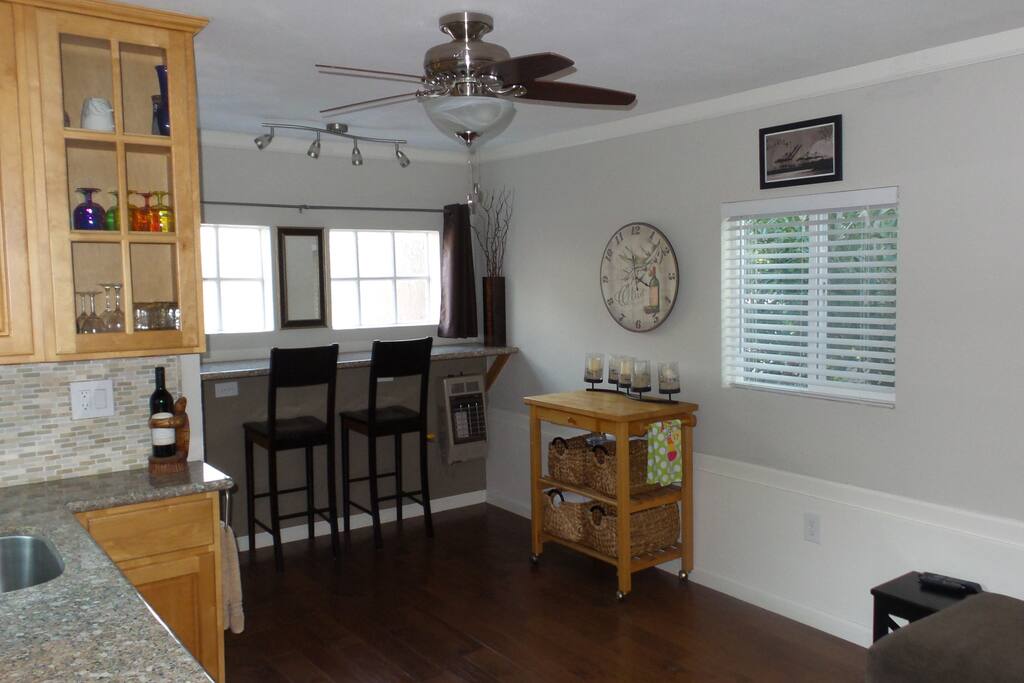 Hardwood floors, lots of natural light, ceiling fan, and sitting bar.