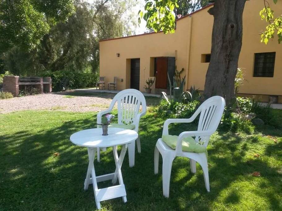 Parrilla y al lado segunda entrada a la casa por la habitación con baño privado.