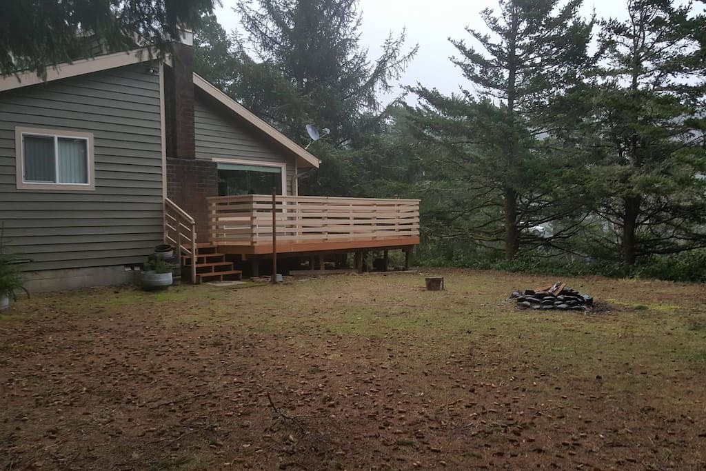 One corner of the backyard, firepit in the center.